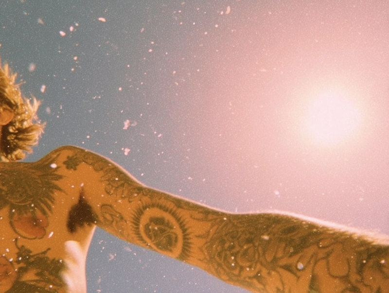 Tattooed arm in golden hour sunlight showing mineral sunscreen protection for tattoos