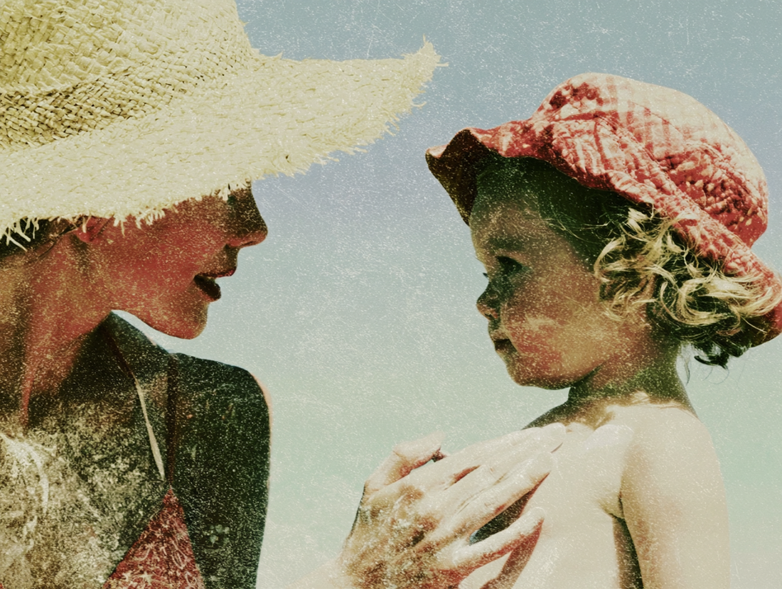 Parent putting sunscreen on a toddler